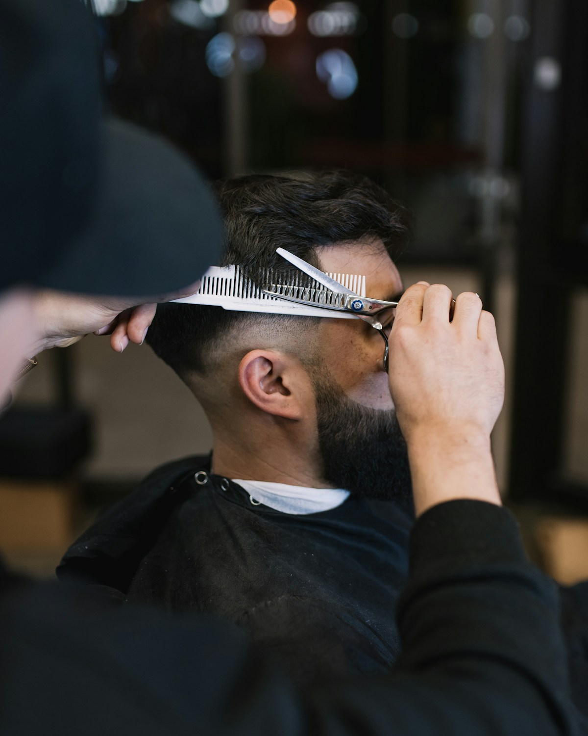 Barbero cortando el pelo a un cliente